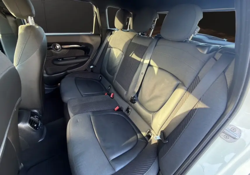 Vue intérieure côté droit des sièges arrière noirs en tissu et cuir d'une MINI Clubman F54 blanche.