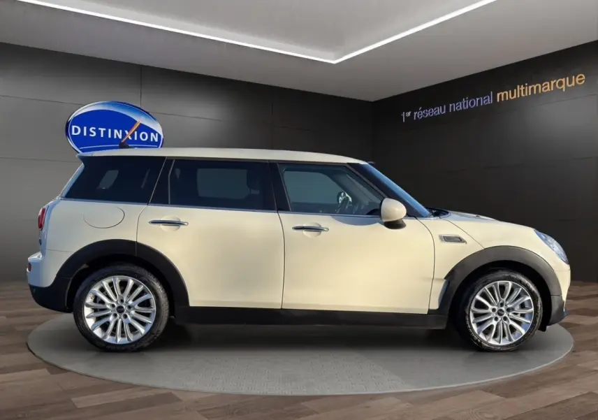 Vue de profil côté gauche d'une MINI Clubman Cooper Exquisite blanche avec toit blanc et jantes alliage.