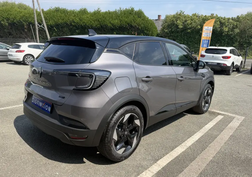 Vue 3/4 arrière droite du Renault Captur 2026 gris Cassiopée bi-ton avec jantes aluminium noires et toit noir.