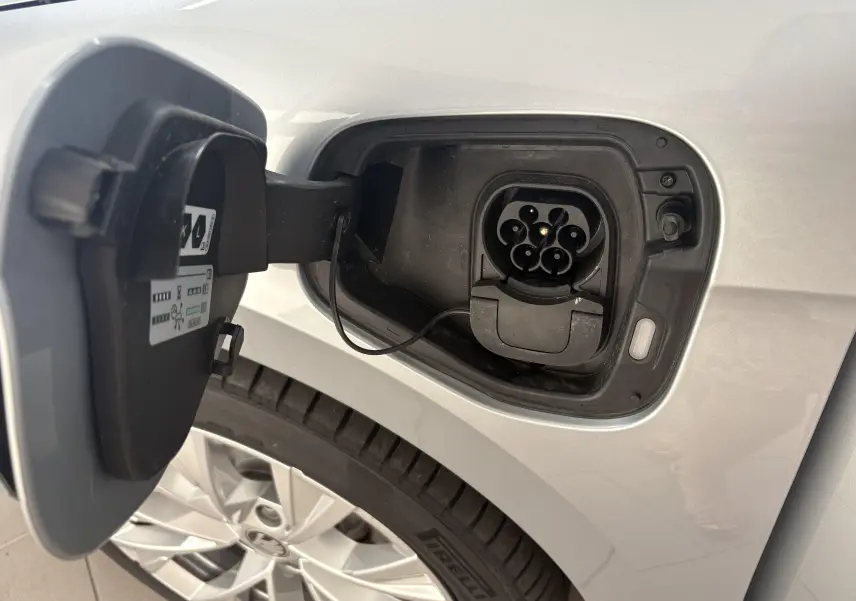 Prise de recharge ouverte côté gauche sur une SKODA SUPERB COMBI gris argent avec jante alliage 18 pouces visible.
