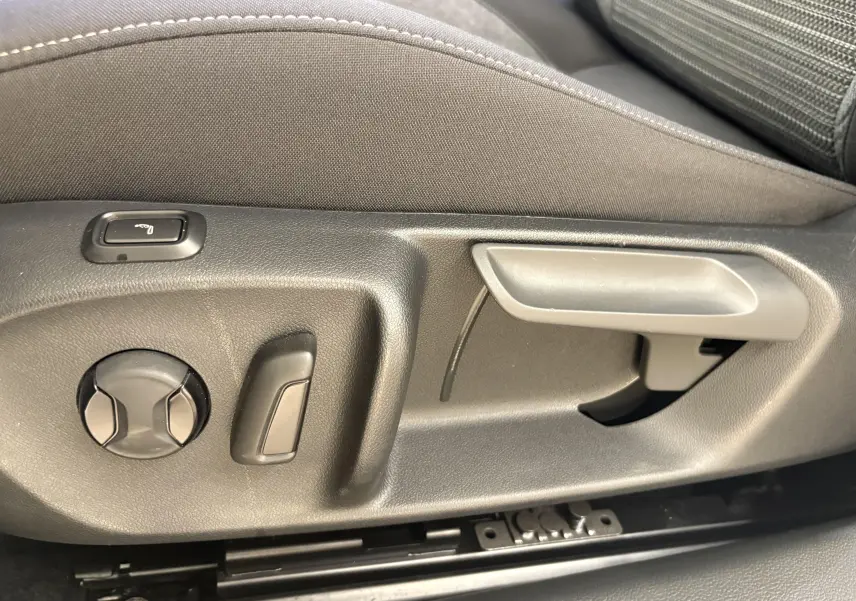 Détail des commandes de réglage manuel du siège avant dans une Skoda Superb Combi gris argent 2025.