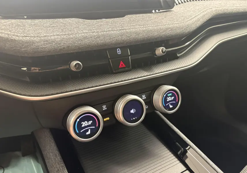 Détail du tableau de bord de la Skoda Superb Combi 2025, montrant les commandes circulaires de la climatisation et les boutons centraux.