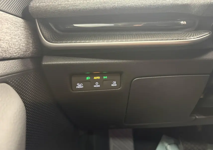 Détail du panneau de commande des feux à gauche du volant dans une Skoda Superb Combi gris argent 2025.