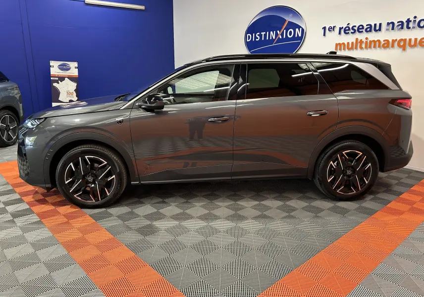 Peugeot 5008 III Hybrid gris titane vue de profil côté gauche, avec jantes noires et détails modernes.