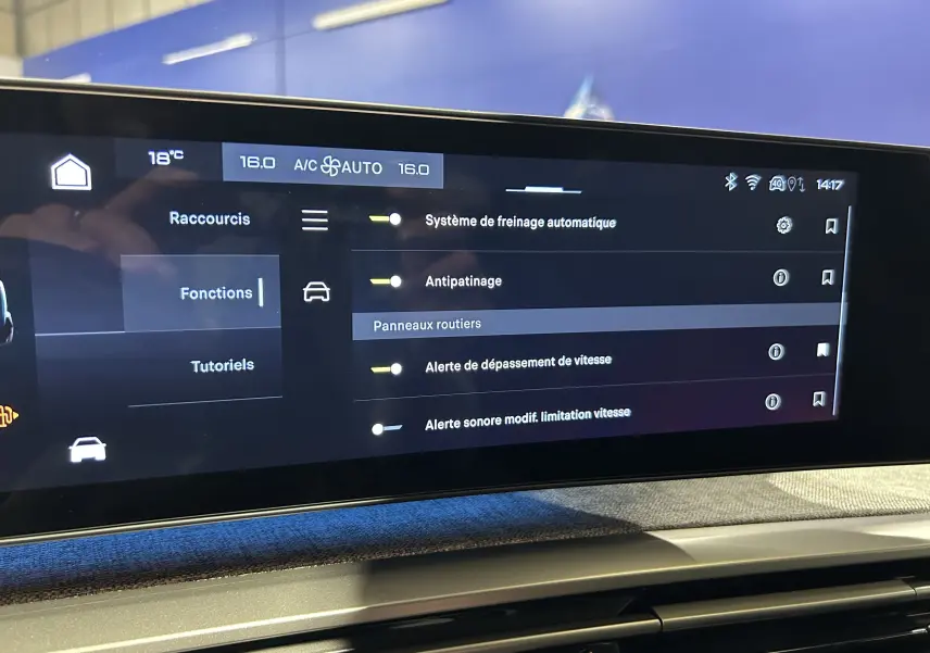 Écran tactile du tableau de bord du Peugeot 5008 Hybrid affichant les réglages d’aides à la conduite et climatisation à 16°C.