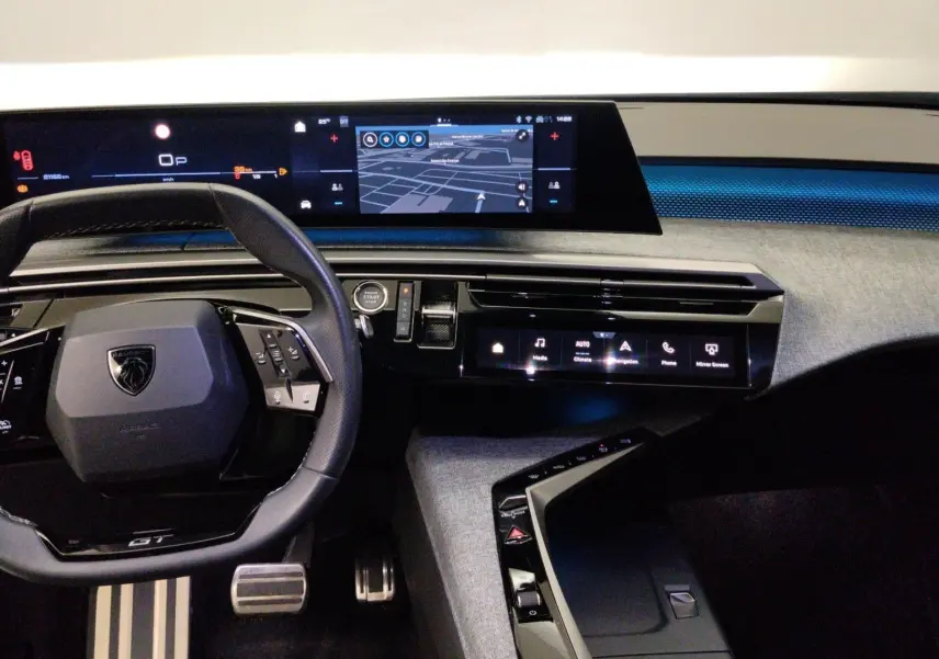 Gros plan sur la roue avant gauche du Peugeot 5008 gris titane, mettant en valeur la jante noire et argentée au design moderne.