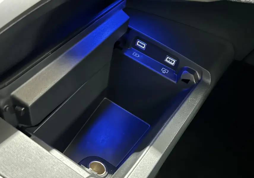 Gros plan sur la console centrale intérieure du Peugeot 5008 III Hybrid, montrant deux ports USB avec éclairage bleu.
