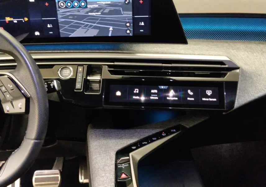 Vue intérieure côté conducteur du Peugeot 5008 III Hybrid 145 e-DCS6 GT, avec tableau de bord numérique et sellerie noire.