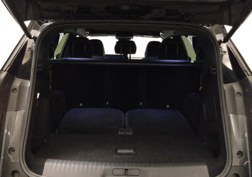Vue intérieure côté droit des sièges arrière en cuir noir avec surpiqûres blanches du Peugeot 5008 III Hybrid 145 GT gris titane.
