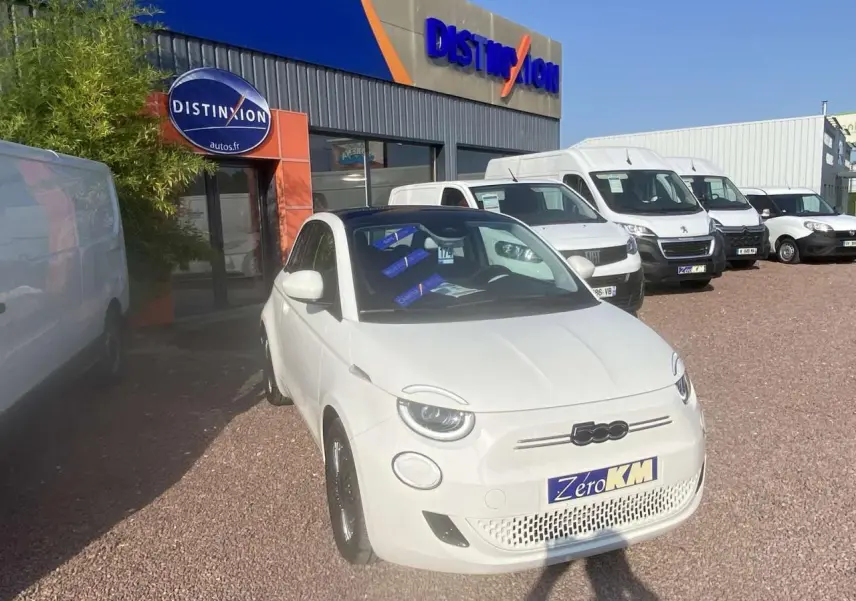 Vue 3/4 avant droite d'une Fiat 500 électrique blanche Ice White avec toit panoramique et jantes noires.