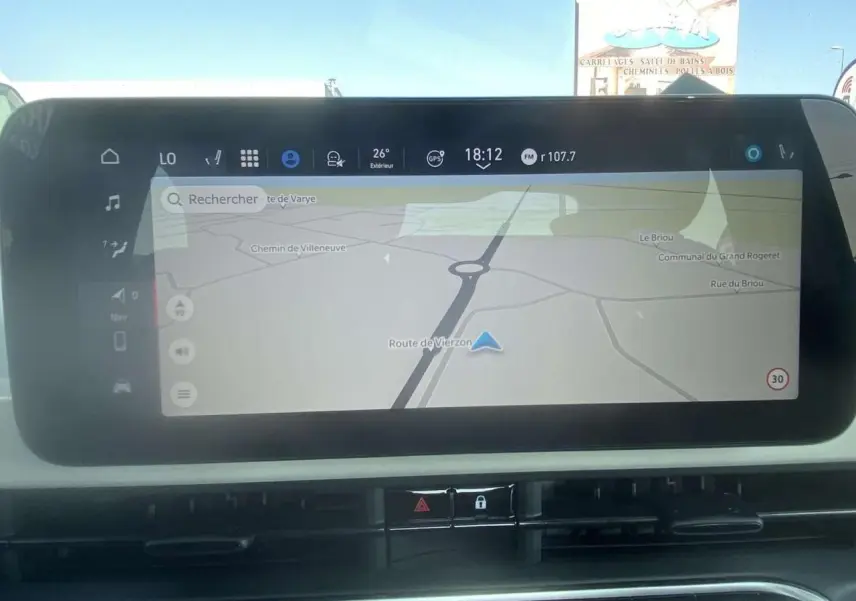 Écran tactile central du tableau de bord de la Fiat 500 Électrique 2022 montrant la navigation GPS en plein jour.