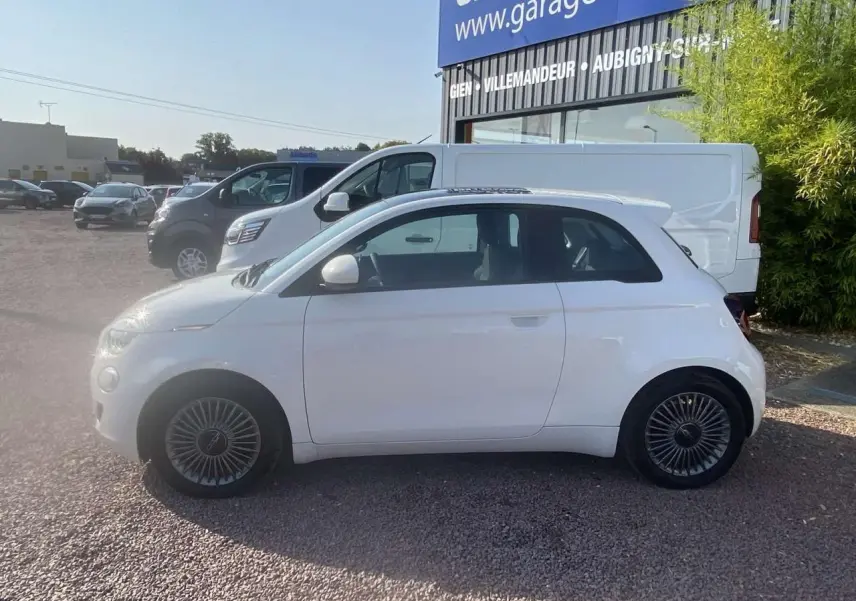 Profil latéral droit d'une Fiat 500 électrique blanche 2022 avec toit panoramique et jantes spécifiques Icône.