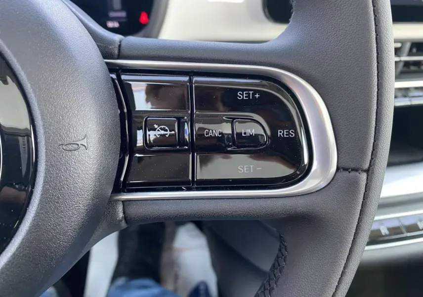 Gros plan sur les commandes de régulateur de vitesse au volant d'une Fiat 500 électrique blanche de 2022.