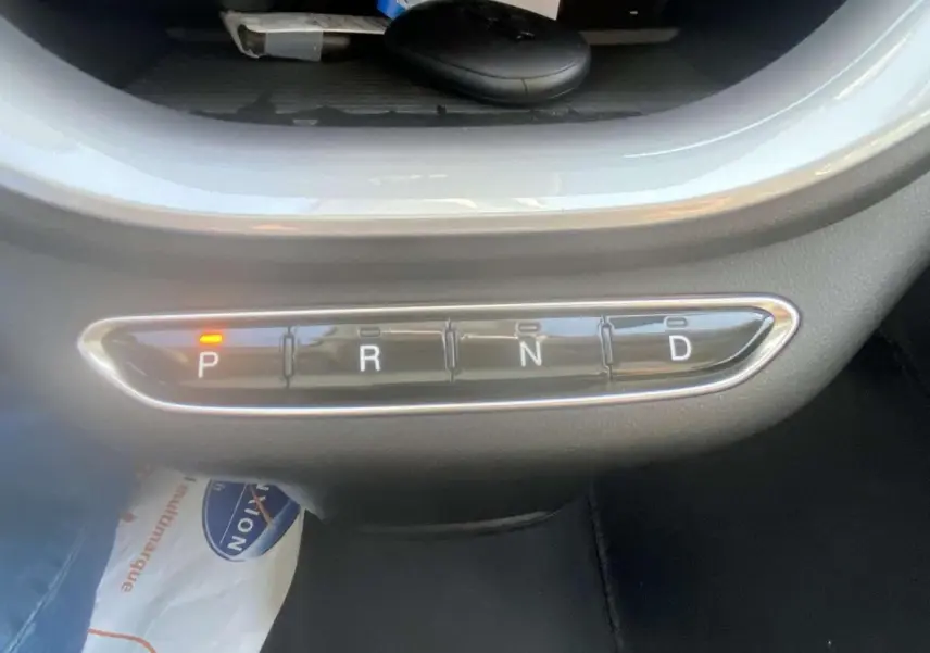 Gros plan sur la commande de boîte automatique de la Fiat 500 électrique blanche, mode parking activé.