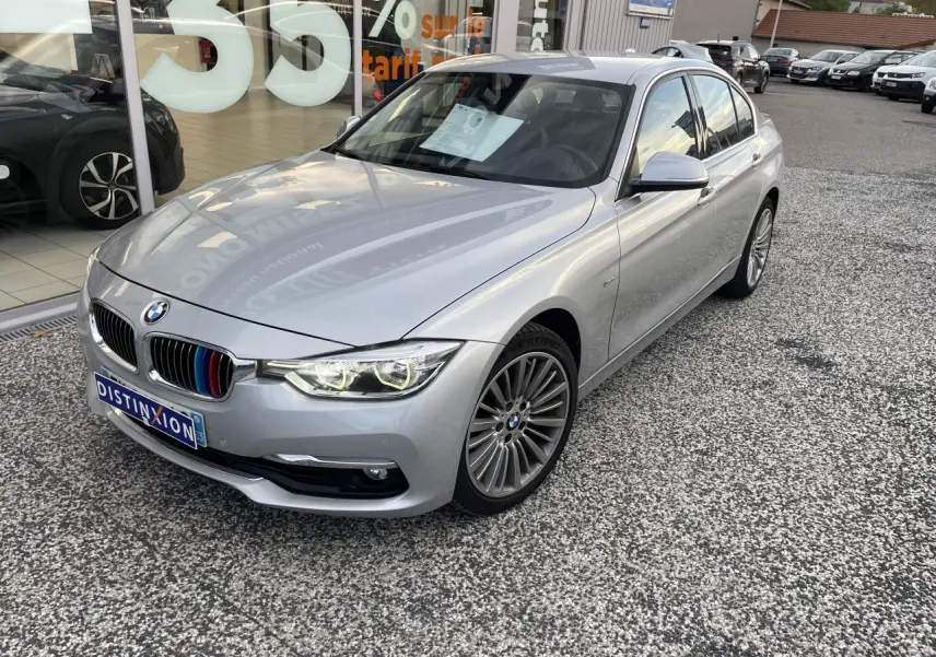 BMW Série 3 F30 gris clair vue 3/4 avant droit avec calandre ornée de liserés tricolores M