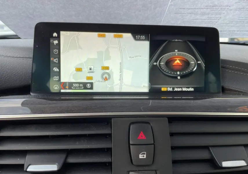 Vue rapprochée de l'écran de navigation et des commandes centrales du tableau de bord de la BMW Série 3 F30 gris clair.