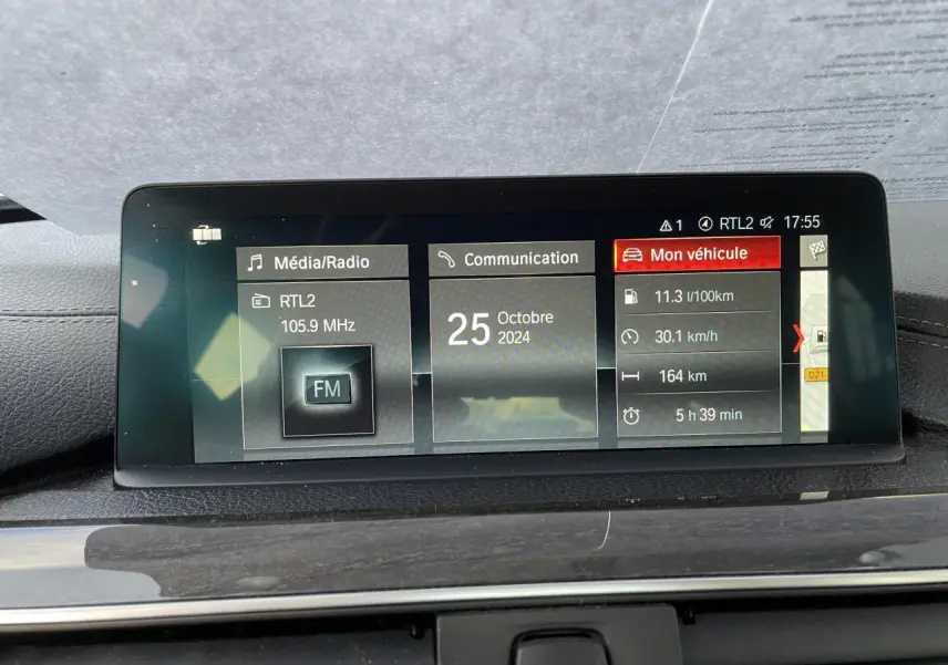 Écran central de la BMW Série 3 F30 330i xDrive 2018 affichant les données de consommation et radio FM.