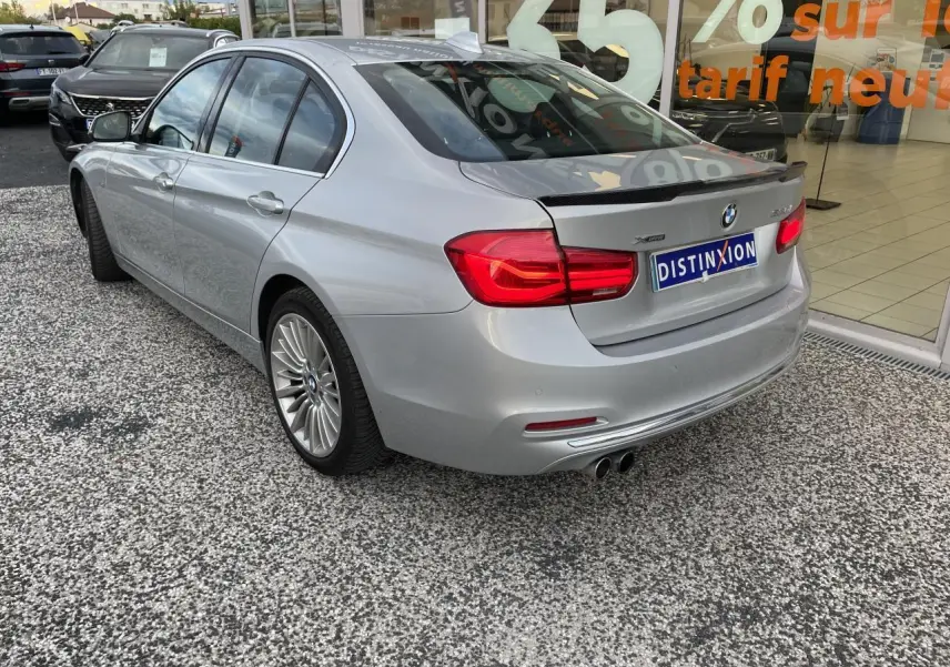 BMW Série 3 F30 330i xDrive gris clair vue 3/4 arrière droit avec jantes alliage et double sortie d’échappement