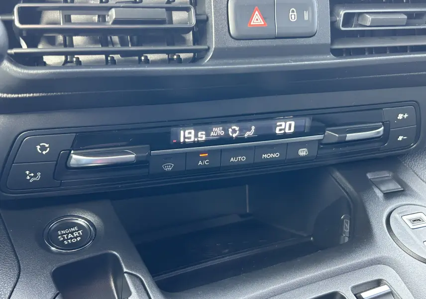 Tableau de bord du Peugeot Partner Fourgon 2025 montrant la climatisation automatique bizone et le bouton start/stop.