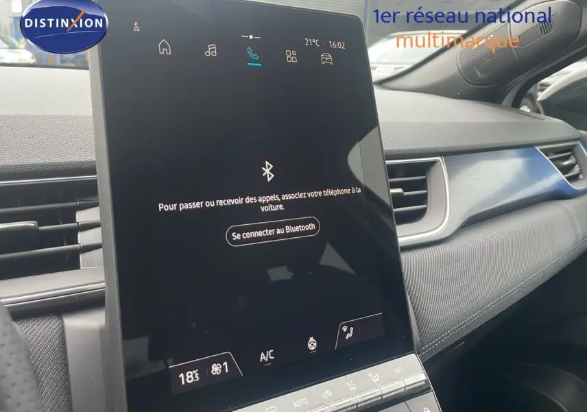 Écran tactile central du tableau de bord du Renault Captur E-Tech blanc nacré, avec détails intérieurs modernes et finition noire.