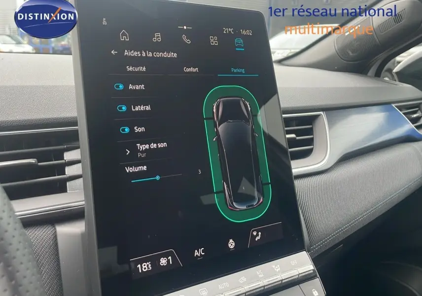 Écran tactile central du tableau de bord du Renault Captur E-Tech blanc nacré, affichant les aides à la conduite en mode parking.