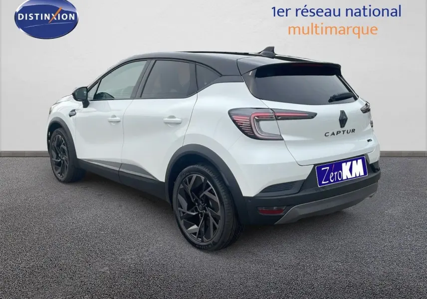 Renault Captur E-Tech hybride blanc nacré avec toit noir, vu de l'arrière côté droit, jantes noires distinctives.