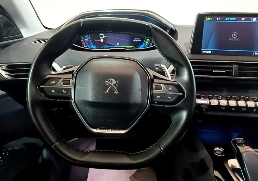 Vue rapprochée du volant cuir noir et du tableau de bord numérique du Peugeot 3008 hybride rechargeable blanc de 2020.