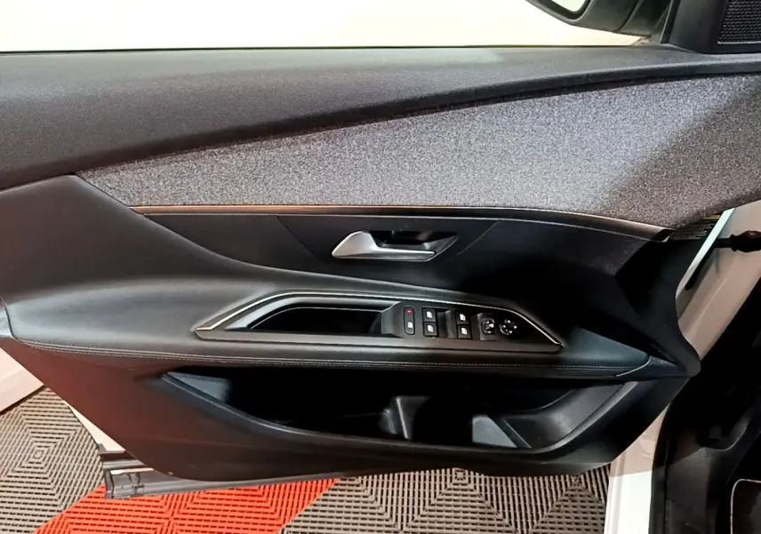 Vue intérieure du panneau de porte avant gauche noir avec commandes électriques sur Peugeot 3008 blanc hybride rechargeable 2020.