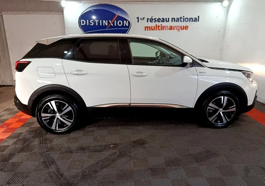 Vue latérale droite d’un Peugeot 3008 blanc hybride rechargeable, avec jantes alliage et toit noir contrasté en intérieur showroom.
