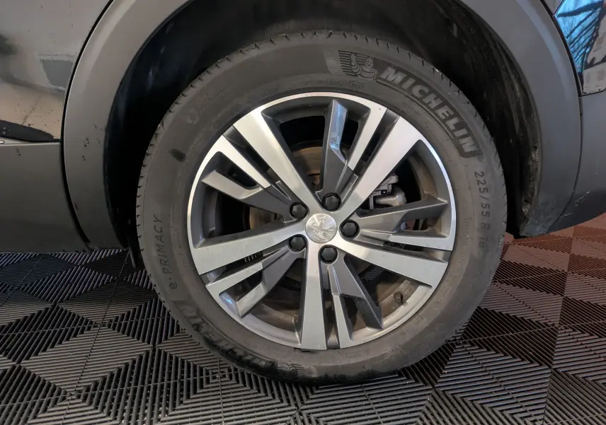 Gros plan sur la jante aluminium 18 pouces bi-ton du côté gauche d’un Peugeot 5008 noir 2024.