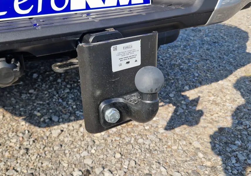 Gros plan sur l'attelage arrière noir du Ford Ranger Super Cabine gris Iconic, montrant la boule d'attelage et la plaque FoMoCo.