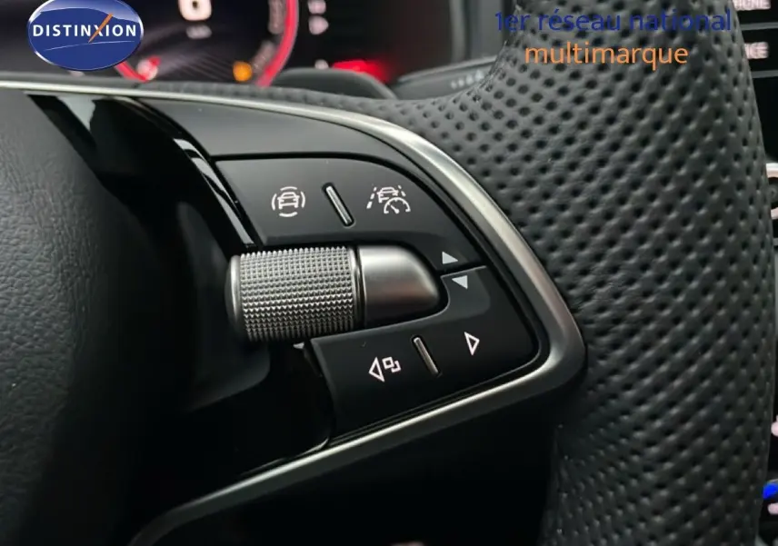 Gros plan sur les commandes multifonctions en aluminium brossé du volant perforé noir du Skoda Karoq gris argent 2025.