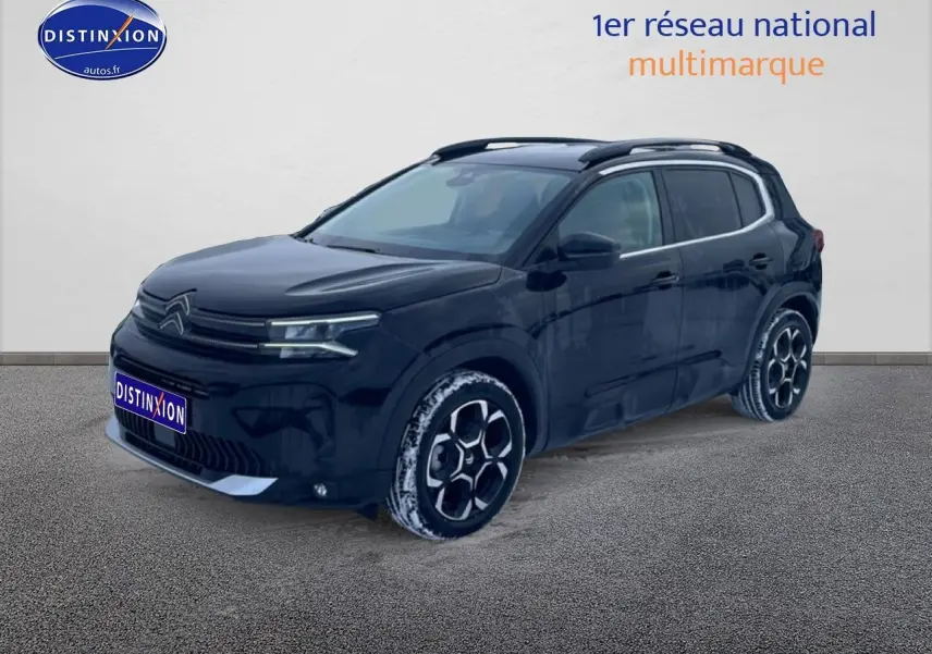 Citroën C5 Aircross noir vue 3/4 avant droit avec jantes alu et barres de toit visibles.