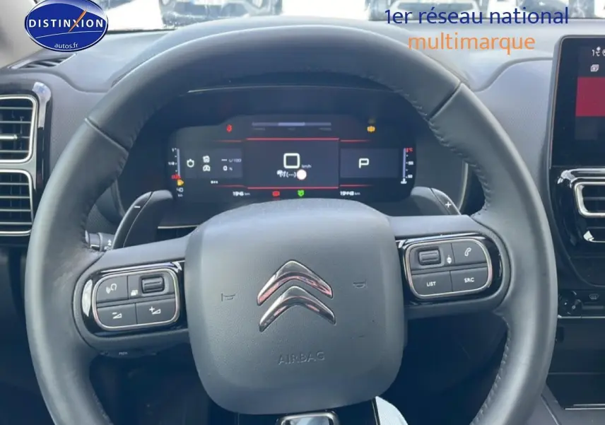 Vue rapprochée du volant cuir noir multifonction du Citroën C5 Aircross 2025 avec tableau de bord digital.