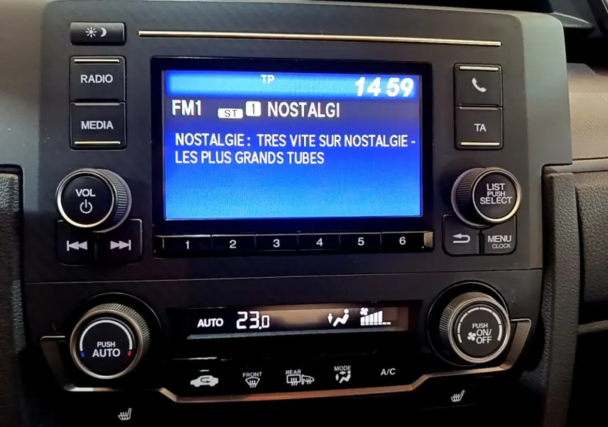 Vue rapprochée du tableau de bord de la Honda Civic 1.0 i-VTEC Exclusive 2020, écran tactile et commandes climatisation visibles.