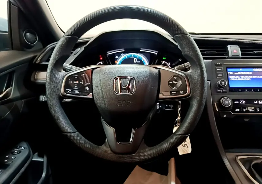 Vue intérieure centrée sur le volant cuir noir et le tableau de bord numérique de la Honda Civic 1.0 i-VTEC Exclusive 2020.