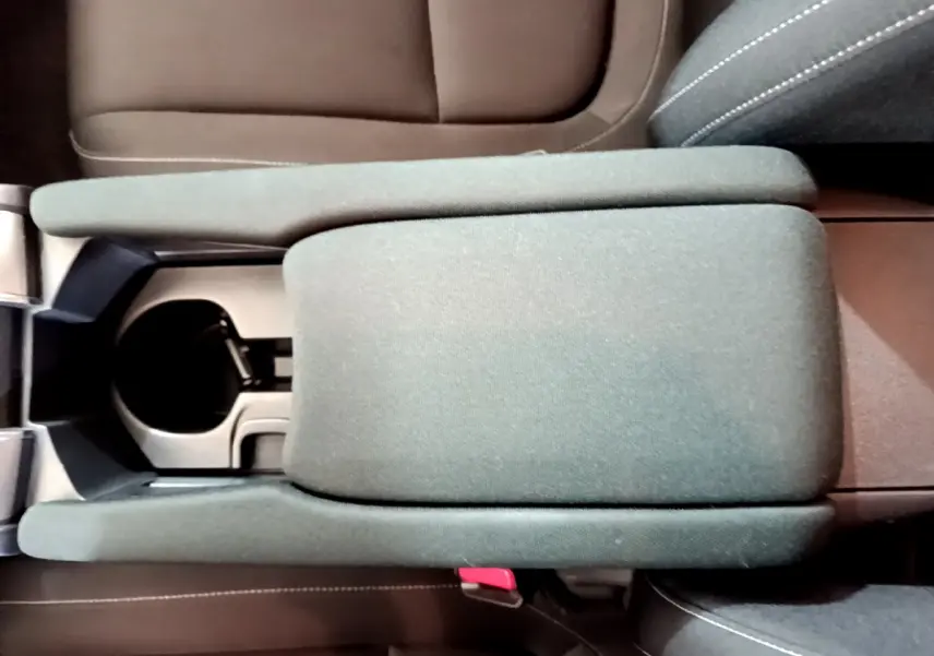 Vue plongeante sur l'accoudoir central gris et les sièges marron de l'intérieur de la Honda Civic 1.0 i-VTEC Exclusive.