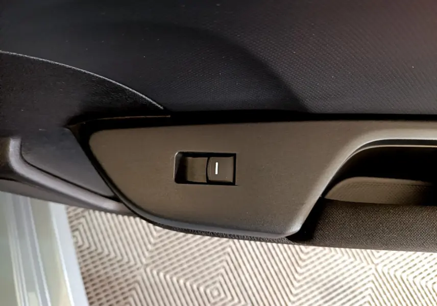 Détail de l'interrupteur noir sur la garniture intérieure de porte d'une Honda Civic gris foncé 2020.