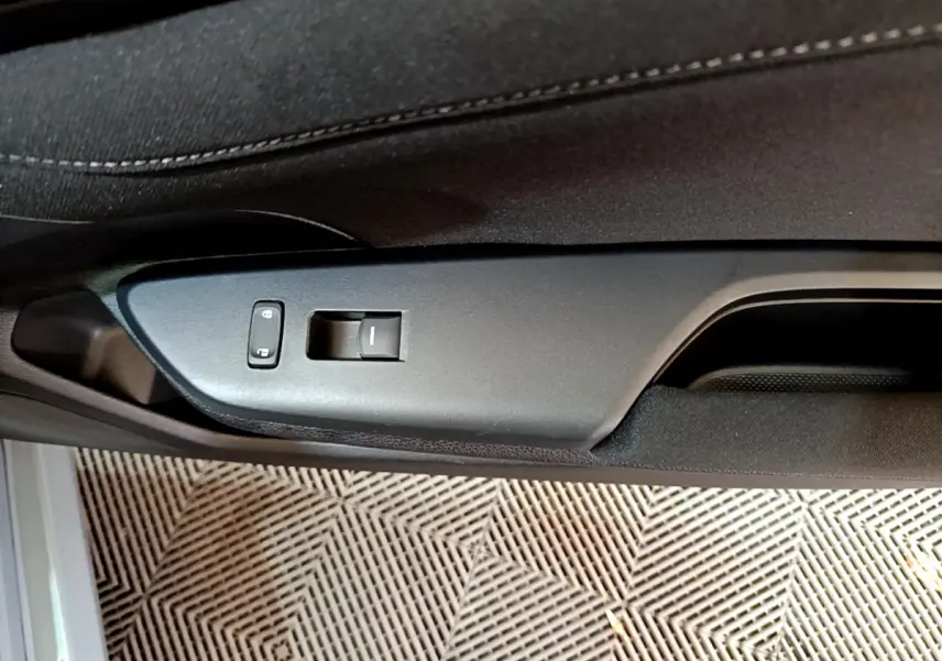 Détail de la commande de verrouillage et lève-vitre sur la porte intérieure côté conducteur d'une Honda Civic gris foncé 2020.