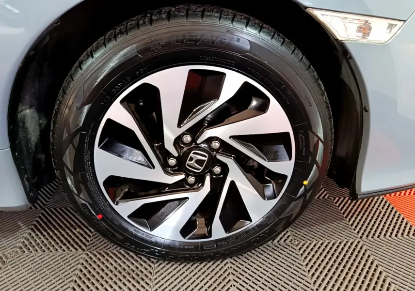 Gros plan sur la roue avant droite de la Honda Civic 1.0 i-VTEC Exclusive gris foncé avec jante alliage bicolore.