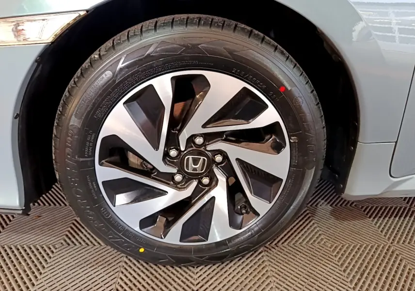 Gros plan sur la roue avant droite de la Honda Civic gris foncé, mettant en valeur la jante alliage au design moderne.