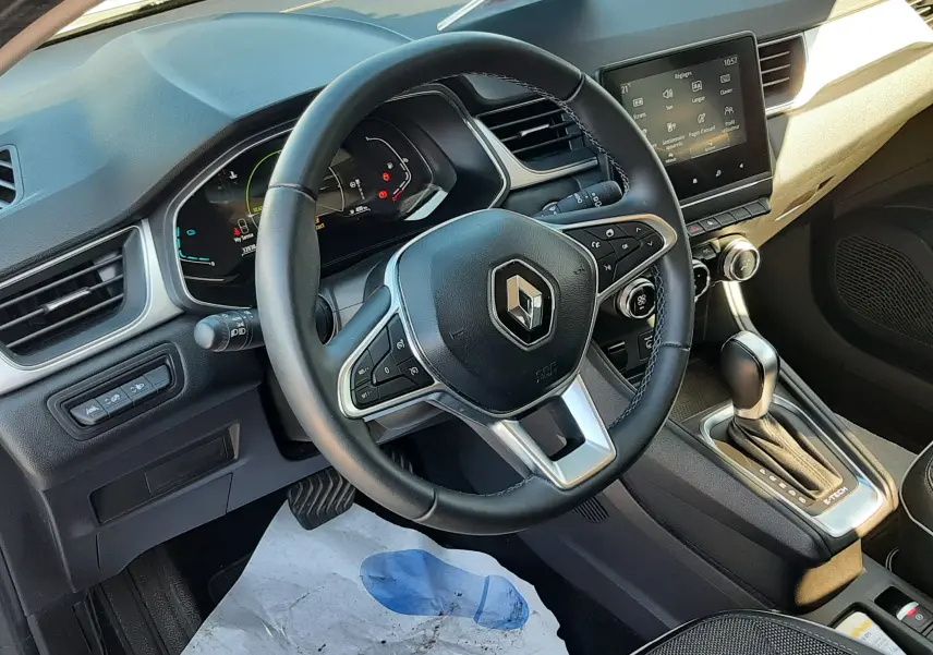Vue intérieure du poste de conduite du Renault Captur E-Tech 145ch Intens 2022, volant multifonction et écran tactile central.