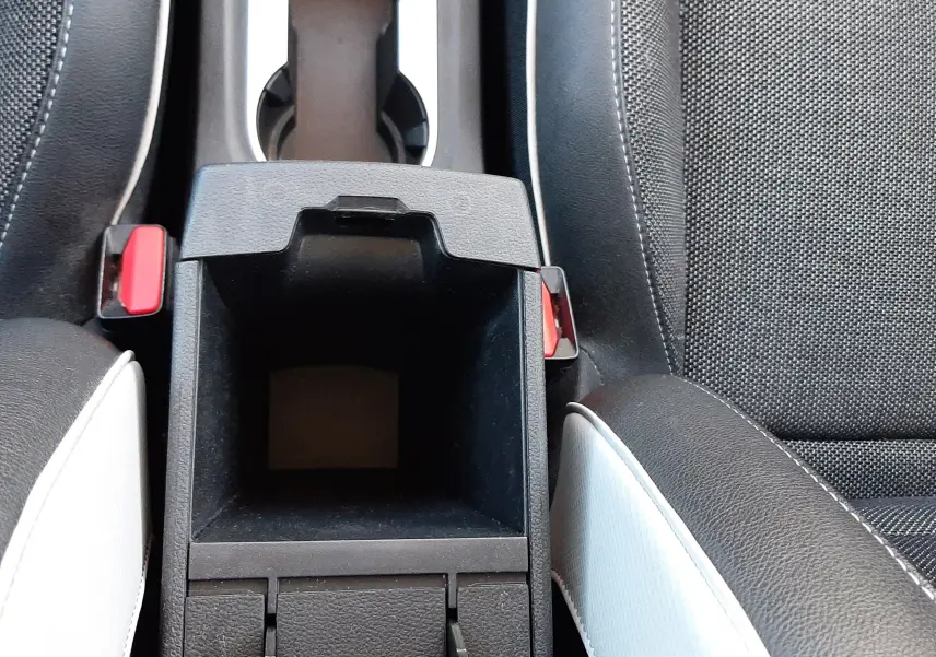 Vue plongeante sur la console centrale ouverte du Renault Captur E-Tech 145ch Intens avec sièges noir et blanc nacré.