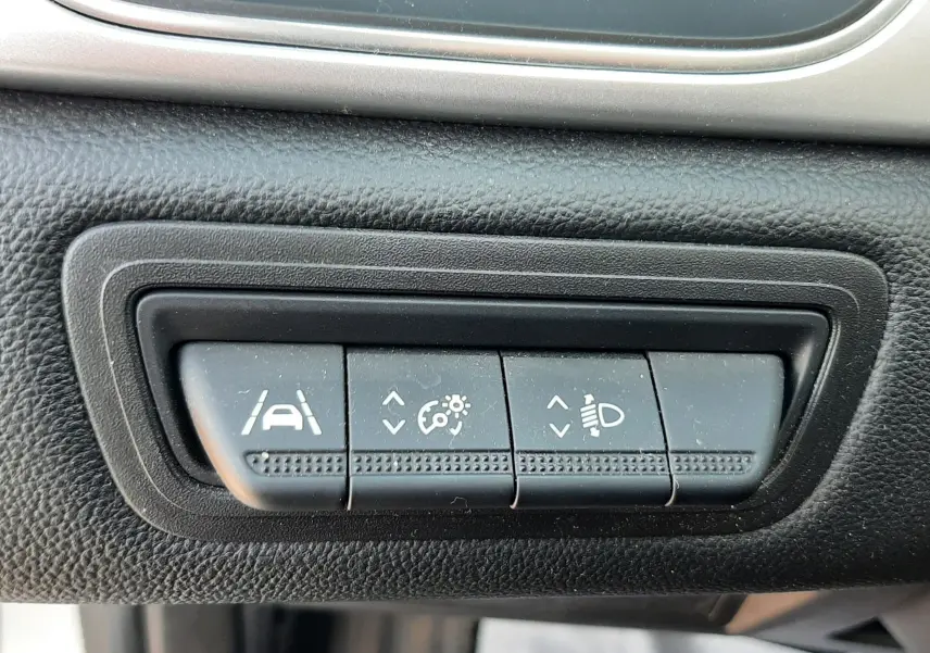 Gros plan sur les boutons de réglage d'assistance à la conduite et des phares dans l'habitacle noir du Renault Captur E-Tech 2022.