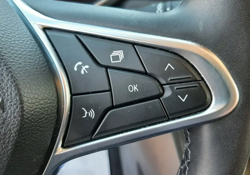 Gros plan sur les commandes multifonctions noires du volant cuir noir du Renault Captur E-Tech 145ch Intens 2022.