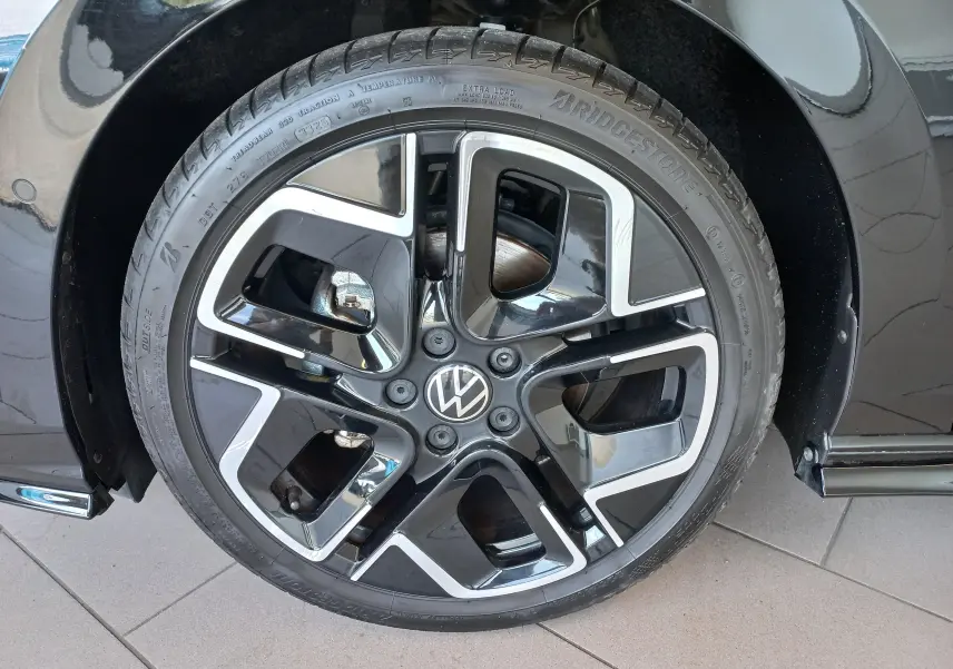 Gros plan sur la roue avant droite de la Volkswagen Golf 1.5 eTSI 150 DSG7 R-Line Edition noir ébène avec jante alliage bicolore.