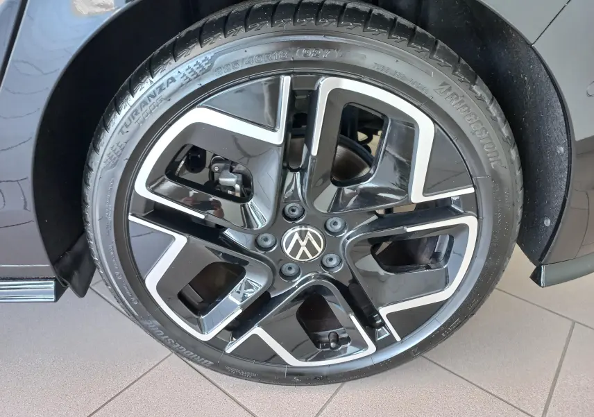 Gros plan sur la roue avant droite de la Volkswagen Golf 1.5 eTSI 150 DSG7 R-Line Edition noir ébène avec jante alliage noire et argent.