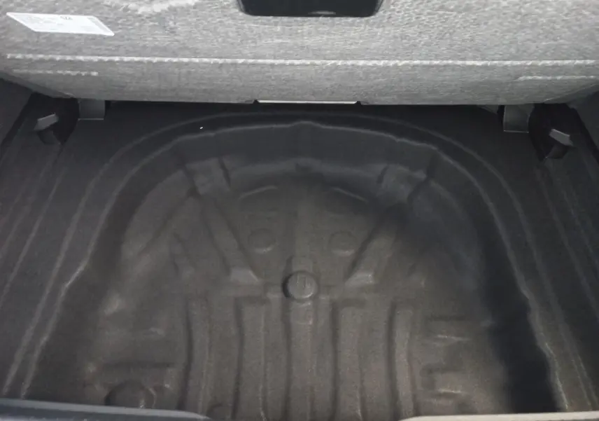 Coffre ouvert en vue plongeante d'une Volkswagen Golf 1.5 eTSI 150 DSG7 R-Line Edition noir ébène, sans roue de secours visible.