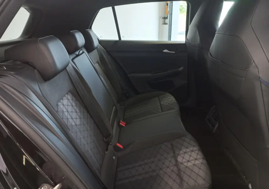 Vue intérieure arrière côté droit de la Volkswagen Golf 1.5 eTSI R-Line Edition 2025 avec sièges en tissu noir à motif géométrique.