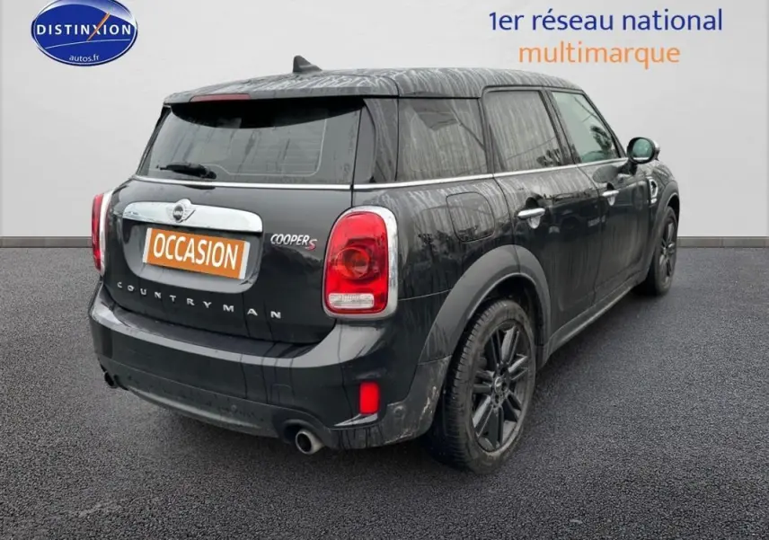 Vue 3/4 arrière droite d'une MINI Countryman noire avec jantes alliage 18 pouces et feux arrière rouges.